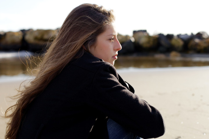 Female teenager looking out at water