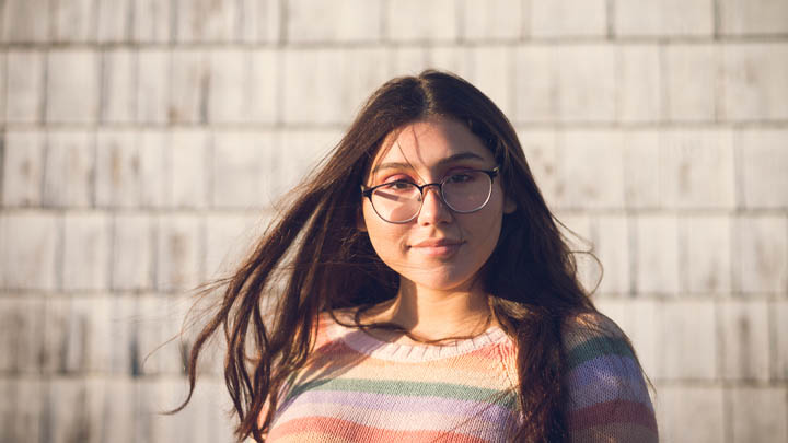 Teenage girl wearing glasses against urban background