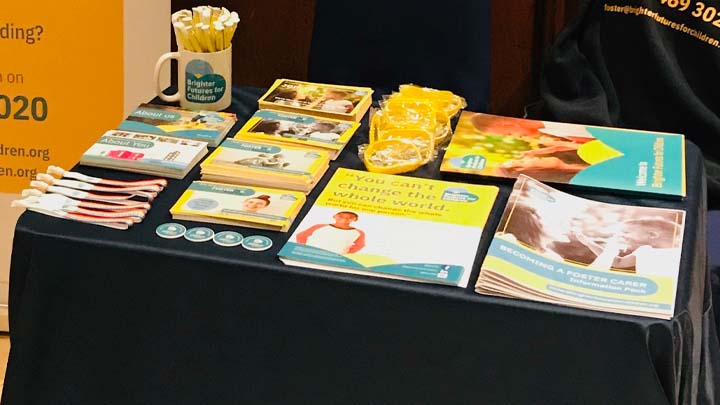 Table covered in fostering promotional materials like pens and posters
