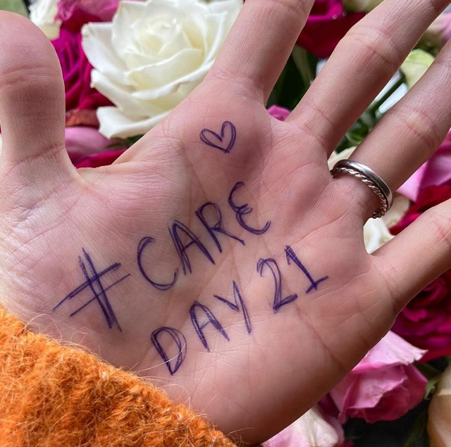 A face-up palm with #CareDay21 written in biro