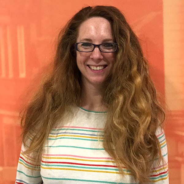 Picture of a smiling Steffi against an orange background