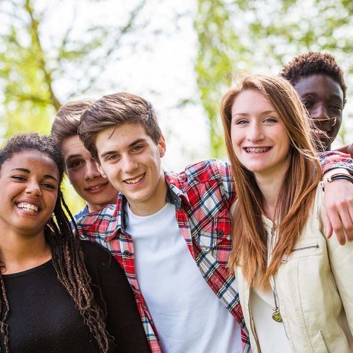 Diverse group of male and female teenagers smiling at camera