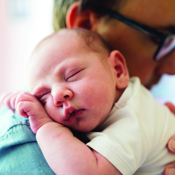 Newborn baby being held by man