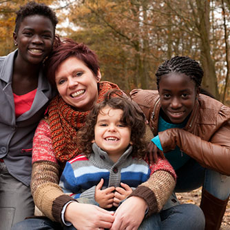 Foster carer family in woods smiling at camera